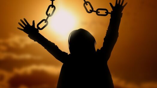 Woman breaking the chains that bound her wrists
